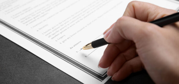 woman-signing-settlement-agreement-redundancy-blog-FEATURED-IMAGE